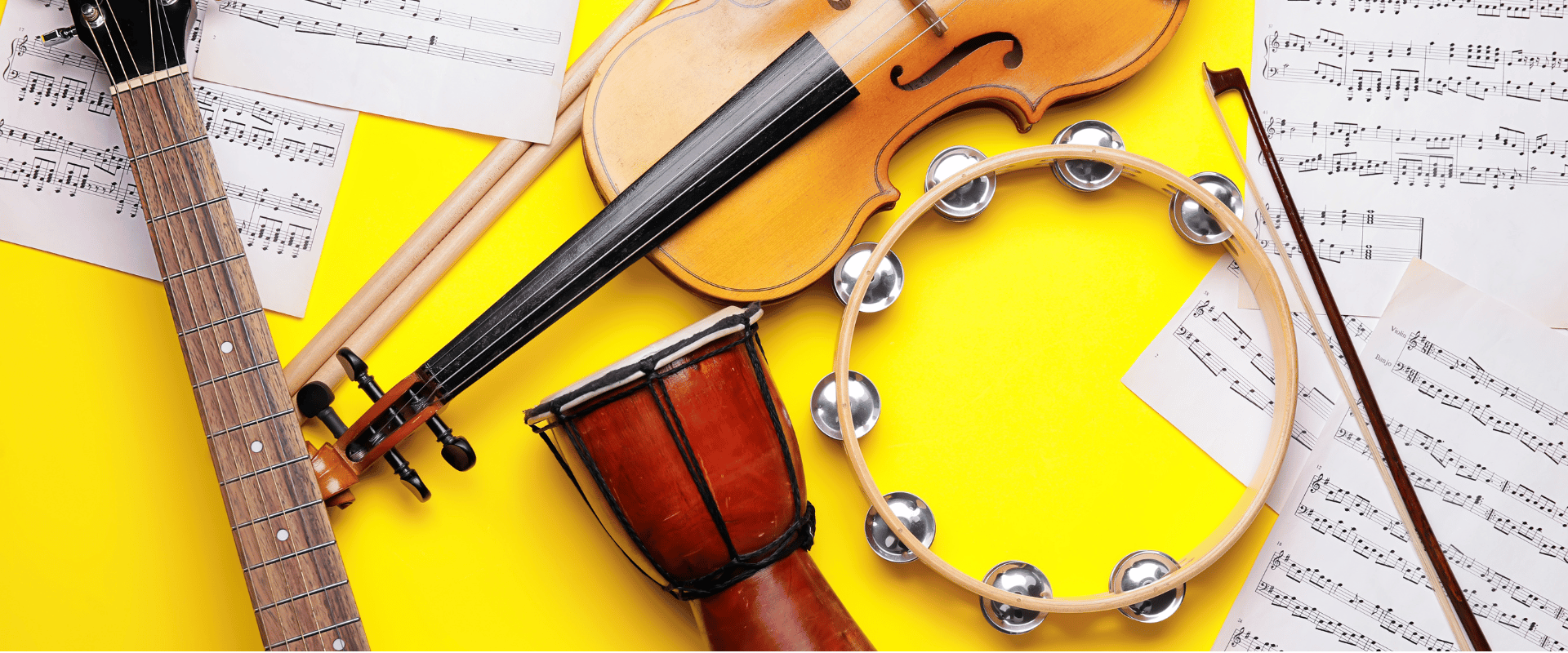 Een compositie van muziekinstrumenten zoals gitaar, viool, drum en tamboerijn met bladmuziek, die creativiteit en zelfexpressie symboliseren voor kinderen.